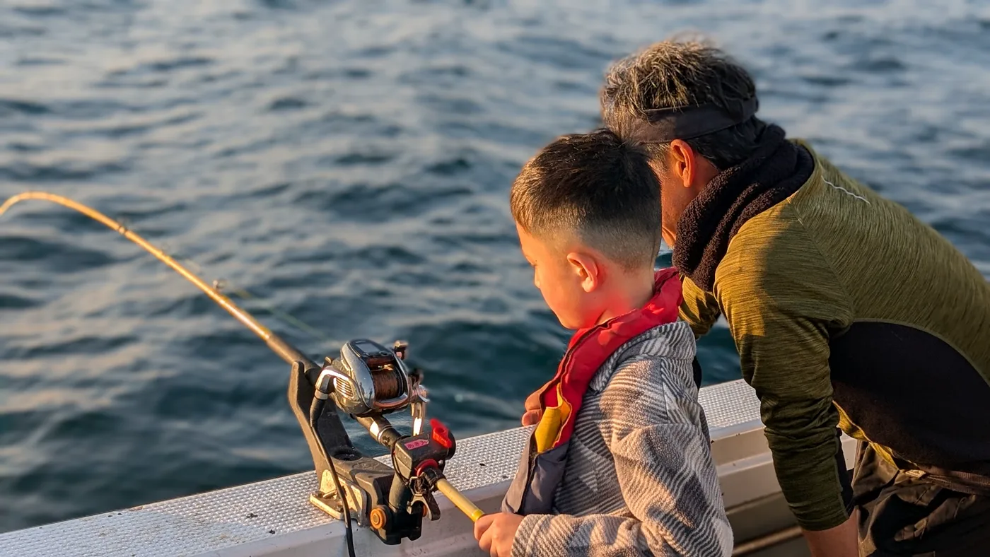 Isaac fishing off the boat in Japan at sunset