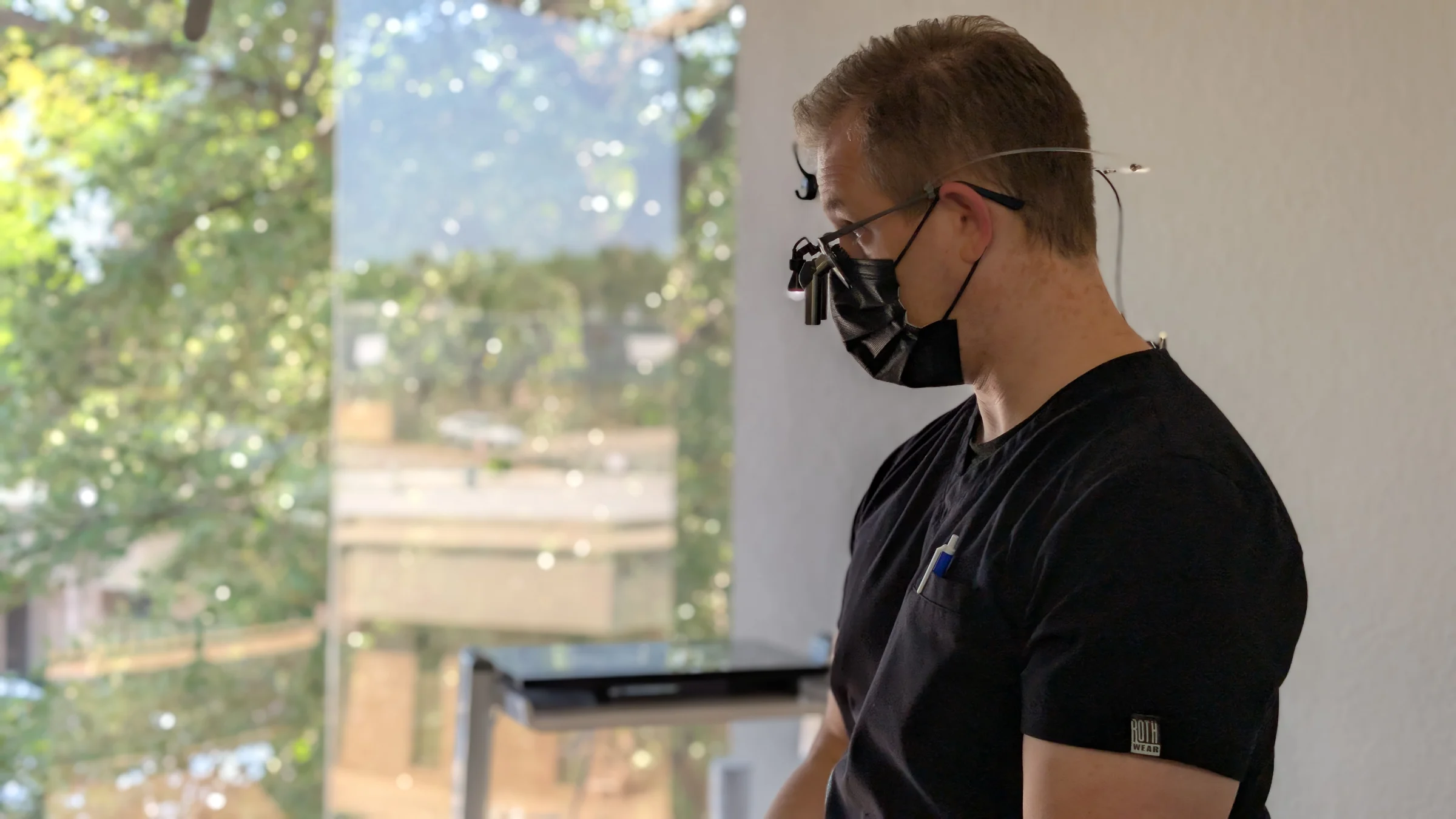 Dr. Baker working in the operatory wearing surgical loupes